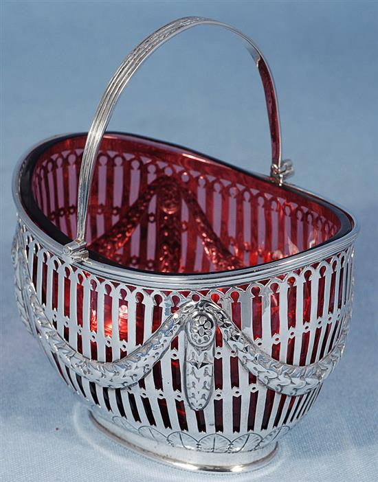 A Victorian silver swing handled sugar basket with cranberry glass liner, length 128mm, weight silver only 5.3oz/151grms